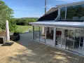 Ny slipad altan med glasveranda och utemöbler. Perfekt för att njuta av sommaren.