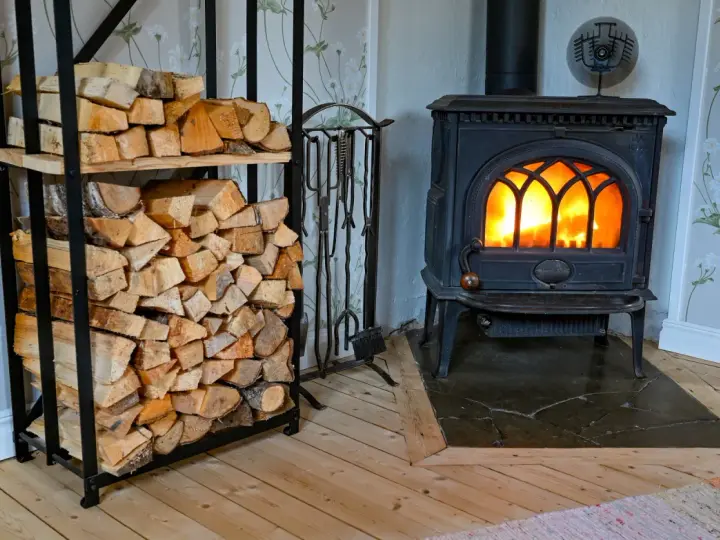 En kamin med glödande eld och en vedstapel redo för att installera kamin.