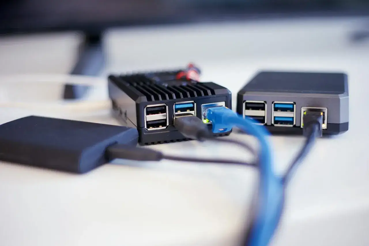 Två Raspberry Pi-enheter med nätverkskablar och en extern hårddisk anslutna. En perfekt setup för en hemmabyggd raspberry pi nas.