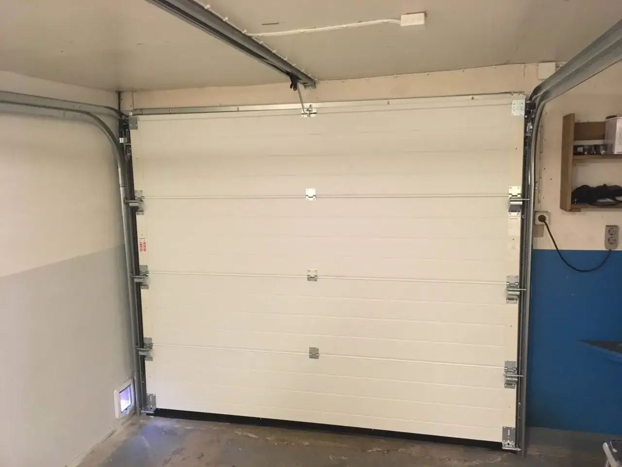 Monterad verisure magnetkontakt på garageporten. Enkel installation för ökad säkerhet.