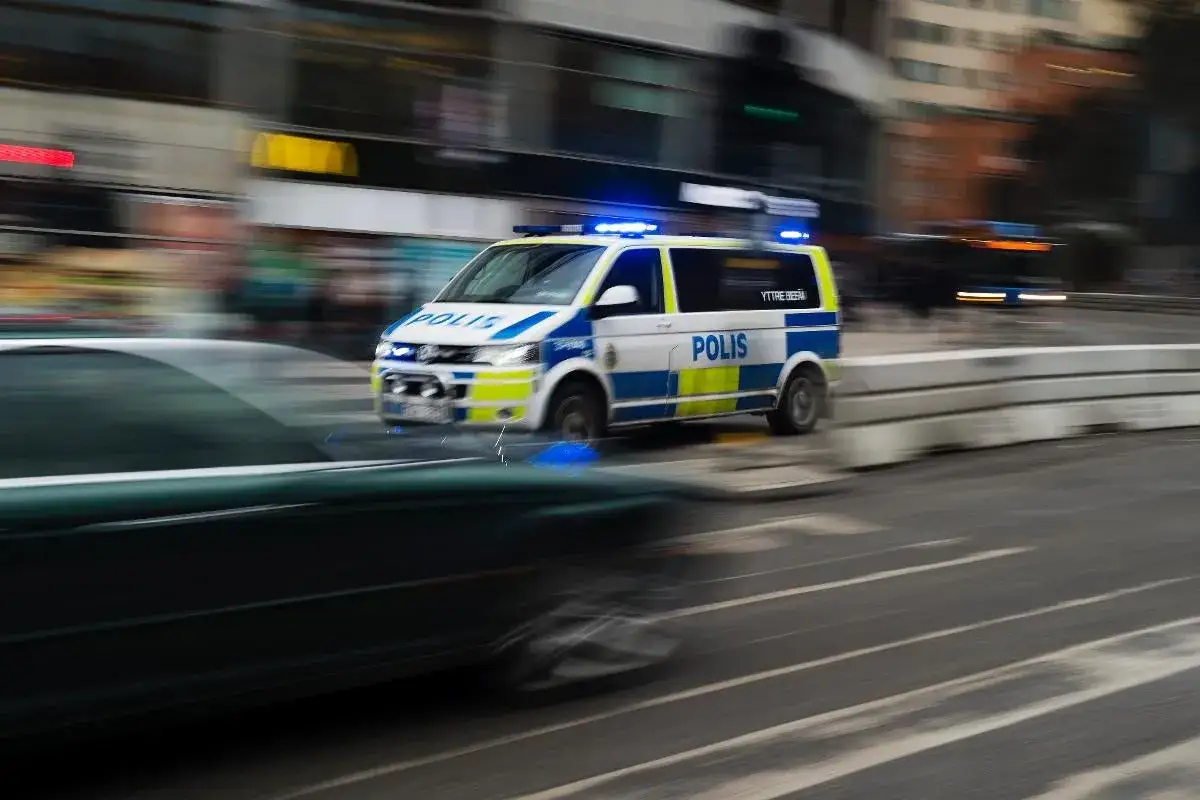 En polisbil med blåljus kör snabbt genom staden. Larmet går, polisen är på väg.